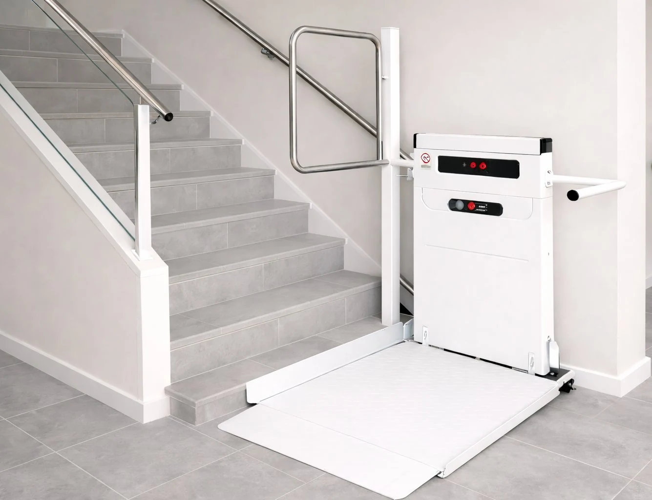 Plateforme élévatrice PMR installée au pied d'un escalier, avec rampe d'accès dépliée pour fauteuil roulant